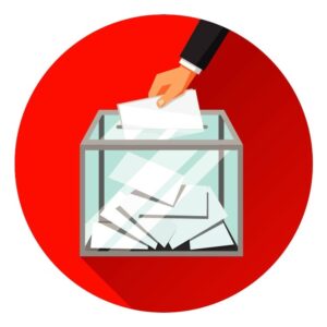 A hand dropping a ballot into a ballot box for votes and referendums