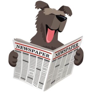 Dog holds and read open newspaper