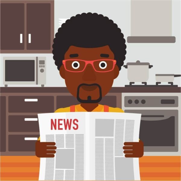 Man reading newspaper in kitchen with kitchen appliances