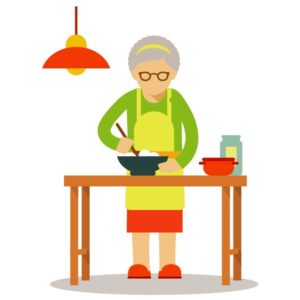 Elderly old woman in apron standing at kitchen table and cooking