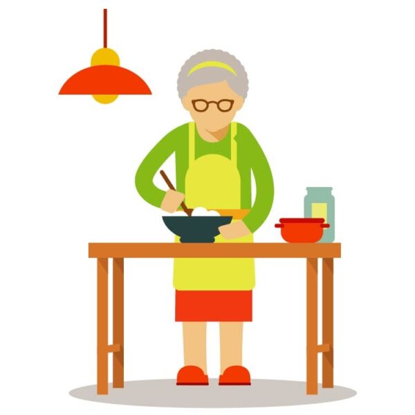 Elderly old woman in apron standing at kitchen table and cooking