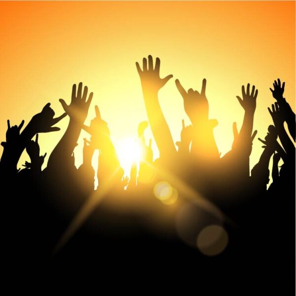 Party crowd on sunburst upraised hands at music festival